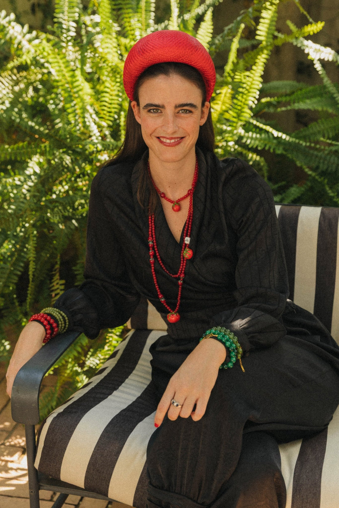 Inés con collares de tomates de porcelana fría pintados a mano