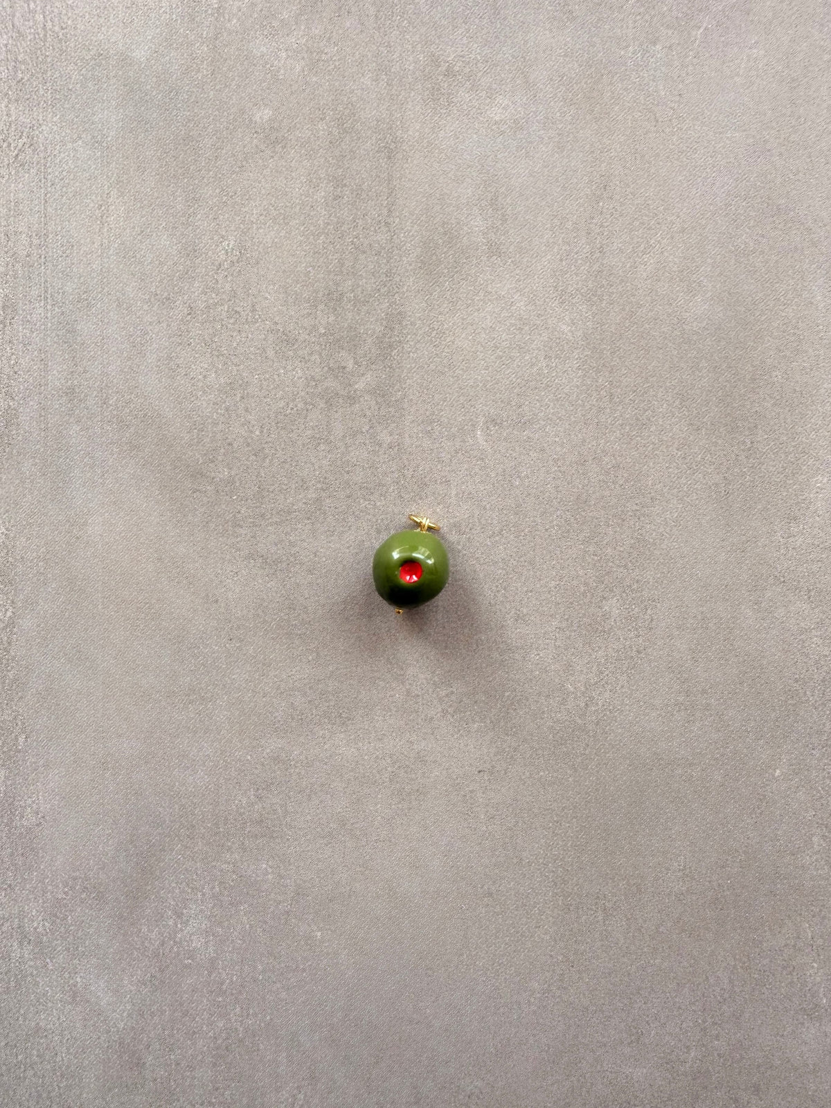 Detalle del charm aceituna hecho a mano en porcelana | esdeinés