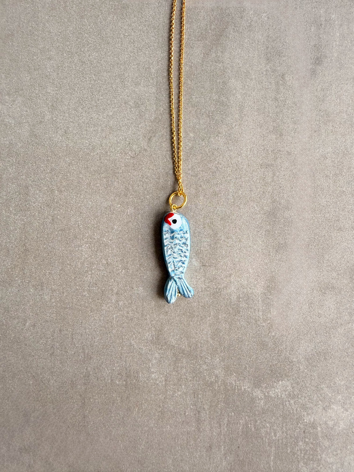 Charm sardina colgado de una cadena bañada en oro de 18k | esdeinés