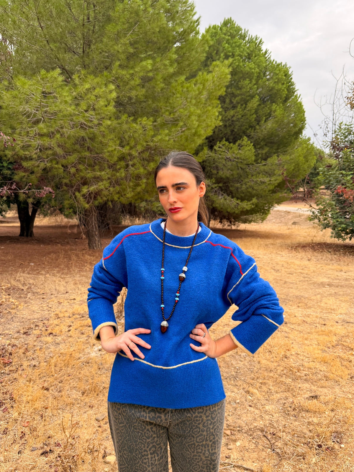 Collar Bellota largo de porcelana pintada a mano, puesto con jersey azul en un look de otoño | esdeinés