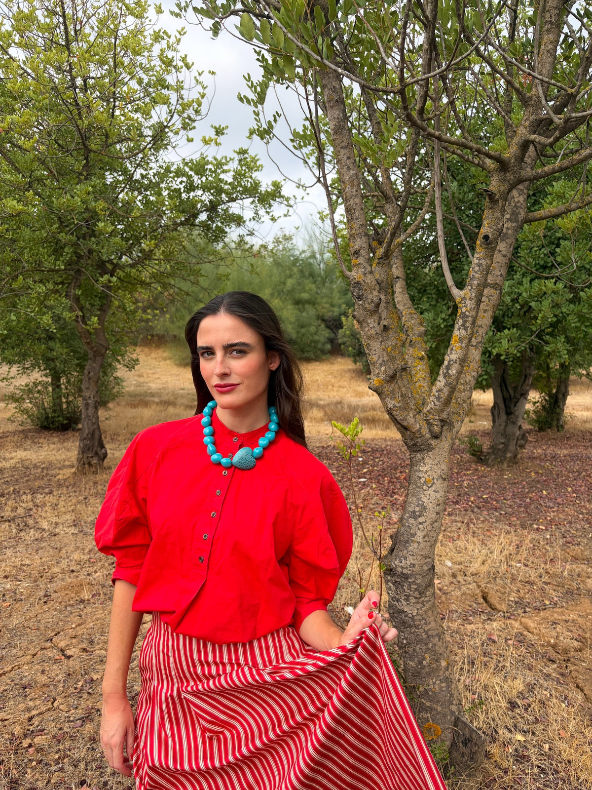 Collar turquesa con corazón grande puesto, look completo con falda de rayas | esdeinés
