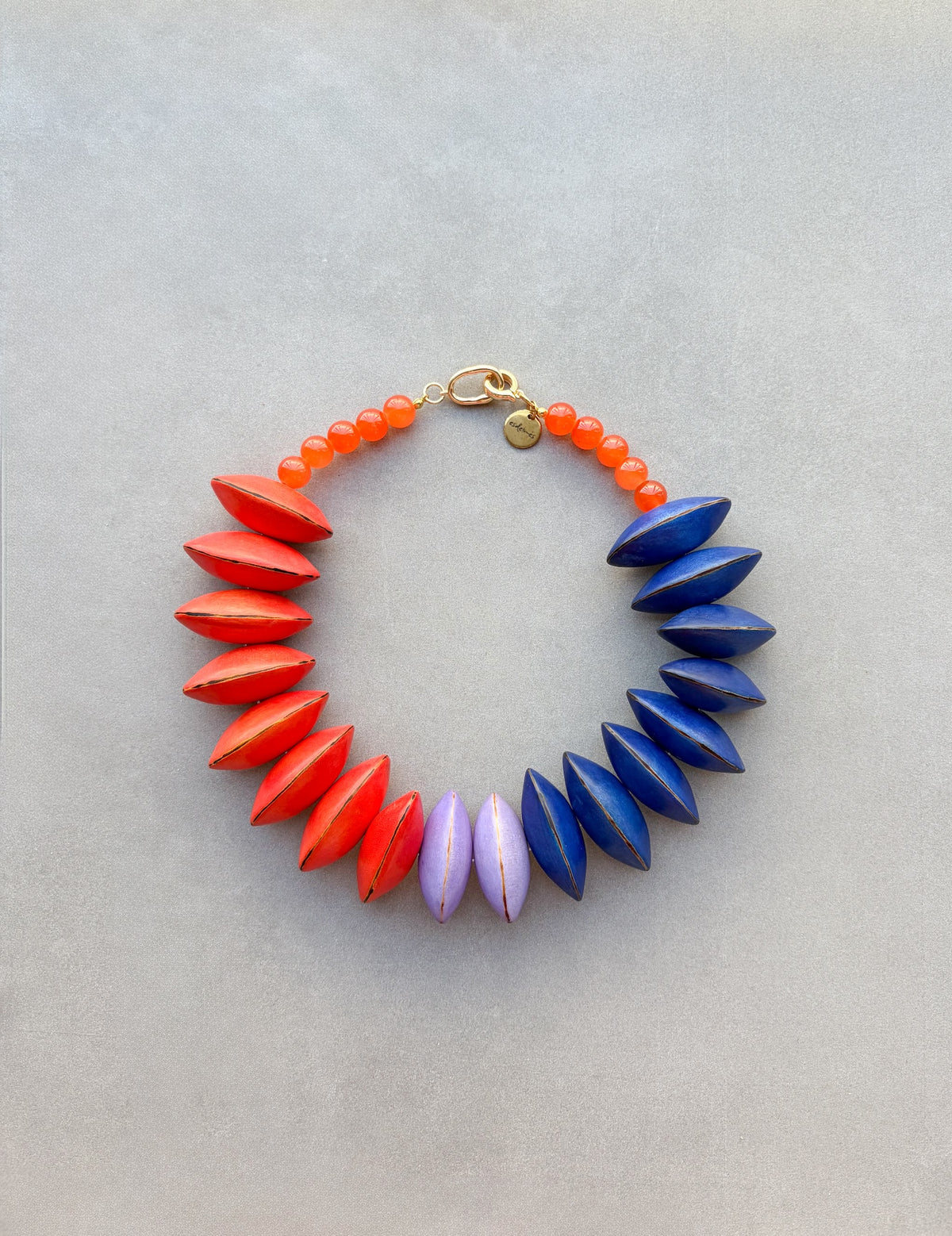 Collar Gola Naranja de semillas de pashaca pintadas en naranja, azulina y lila, vista frontal | esdeinés