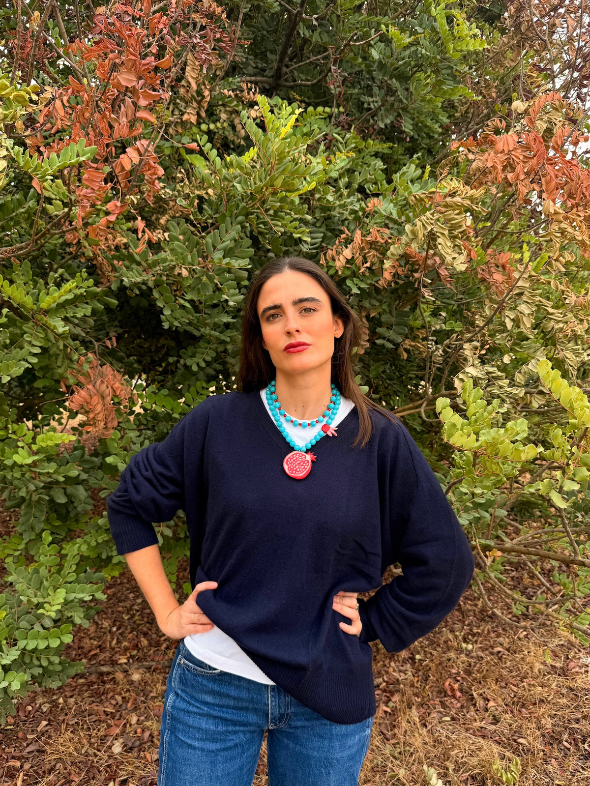 Collar Granada puesto: granada de porcelana y cuentas de jade turquesa sobre jersey marino | esdeinés