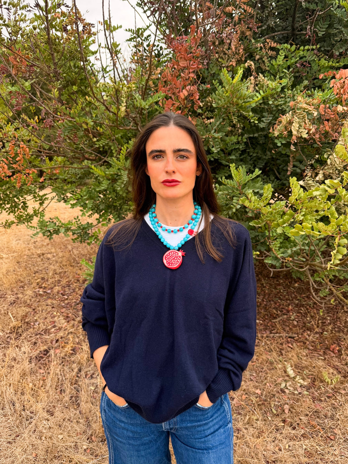 Collar Granada de porcelana pintada a mano y jade turquesa, puesto con jersey azul marino | esdeinés