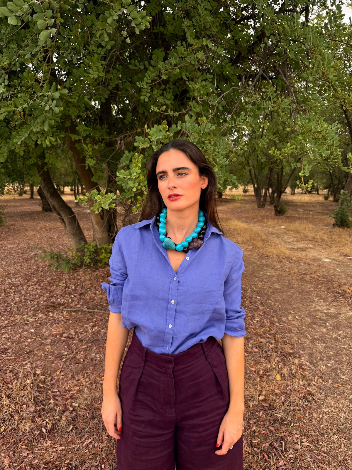 Collares Corazón Turquesa y Corazón Berenjena puestos juntos sobre camisa azul | esdeinés